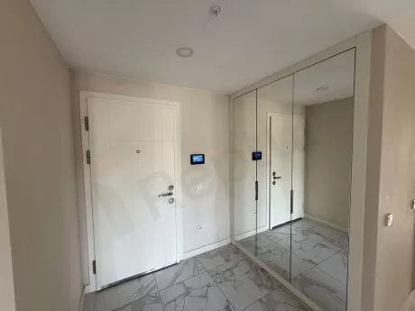 Modern bir dairenin giriş kapısı ve geniş antre alanı.