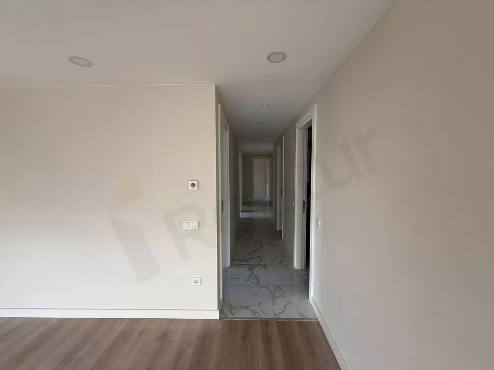 Modern, geniş ve aydınlık bir apartman dairesi koridoru.