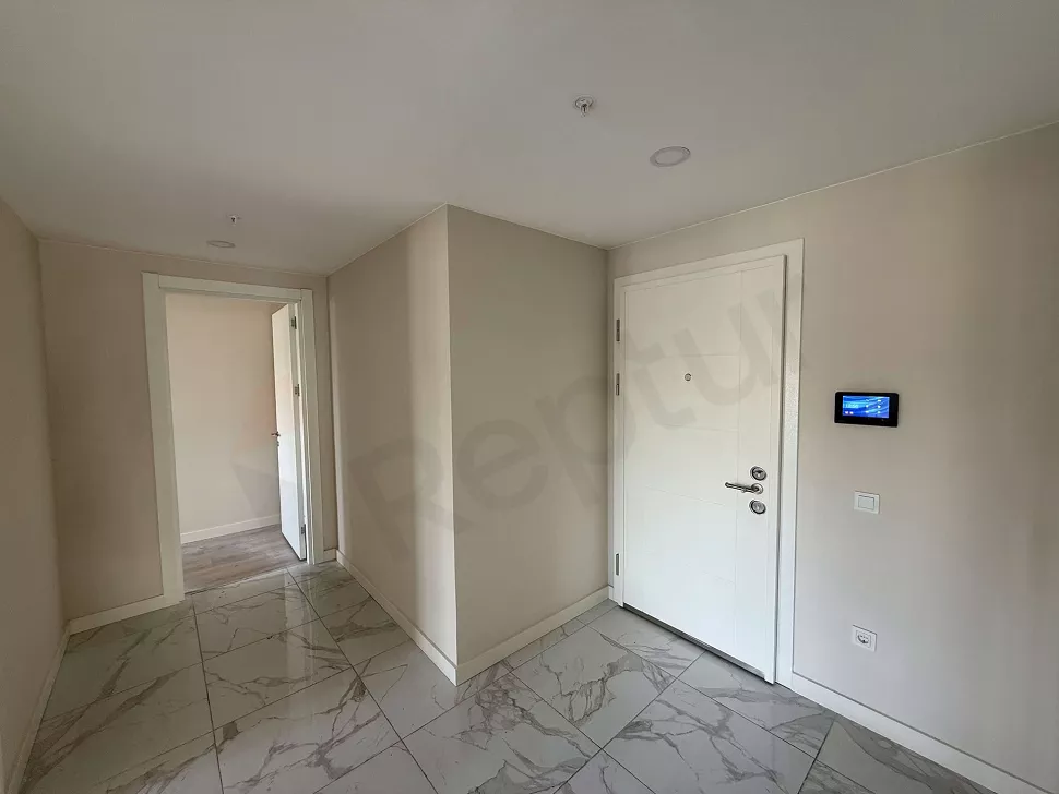 Modern bir apartman dairesinin giriş kapısı ve antre bölümü.