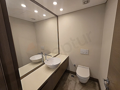 Modern tasarımlı, lüks detaylara sahip dubleks daire banyo görseli. Beyaz seramikler, geniş duşakabin ve şık aydınlatma.