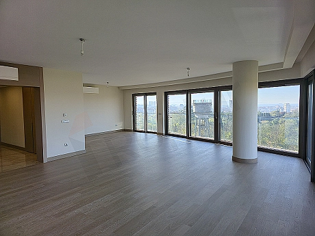 Modern tasarımlı oturma odası iç mekanı, geniş pencereler, şık mobilyalar ve aydınlık atmosfer.