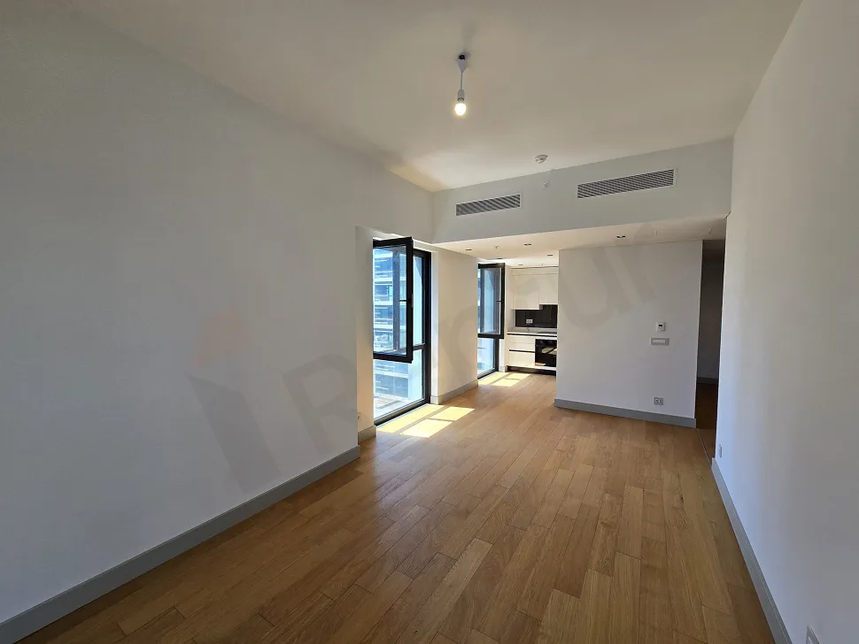 Modern mimariyle tasarlanmış, geniş pencereli ve ferah bir oturma odası görünümü.