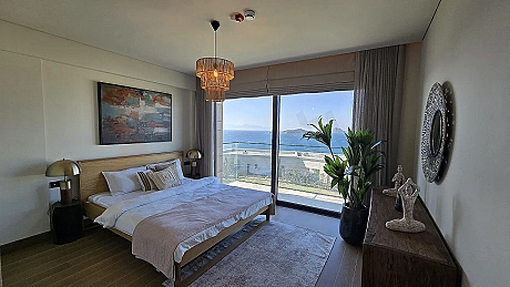 Bodrum'da denize sıfır lüks bir villanın modern tasarımlı ve gün ışığı alan geniş yatak odası alanı.