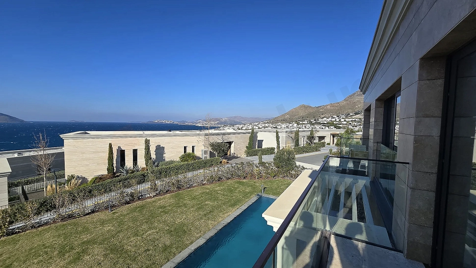 Bodrum'da denize sıfır konumdaki lüks bir villadan görünen panoramik deniz ve sahil şeridi manzarası.