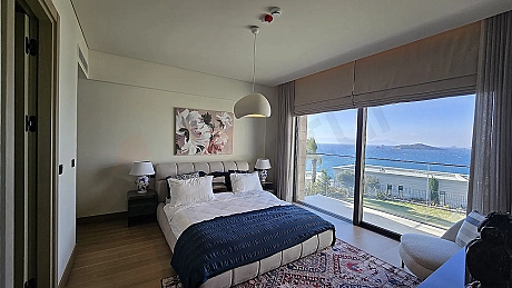 Geniş pencereli, modern ve aydınlık bir villa yatak odası tasarımı.