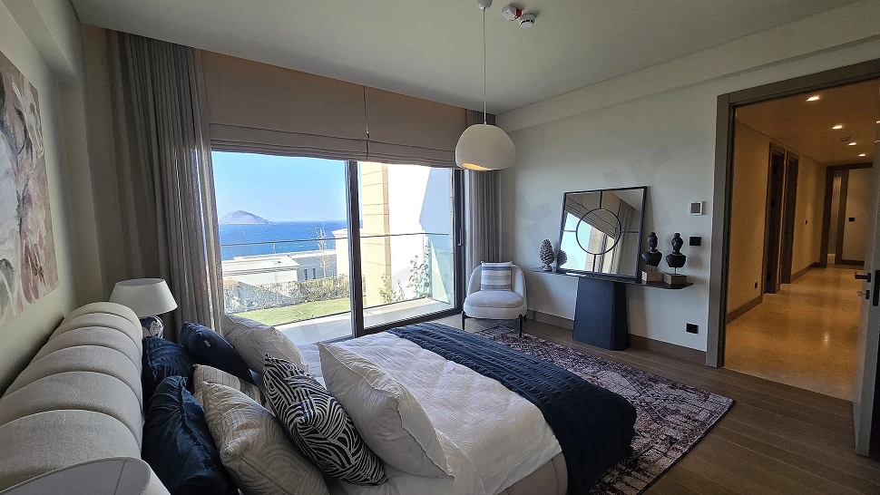 Modern mimariye sahip, geniş ve aydınlık bir villa yatak odası görünümü.