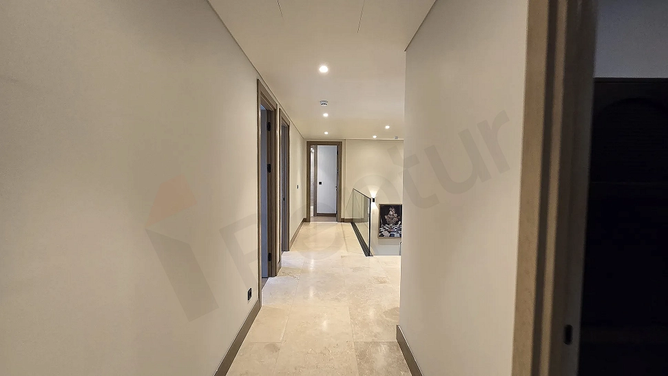 Modern tasarımlı, geniş ve aydınlık lüks villa koridoru.