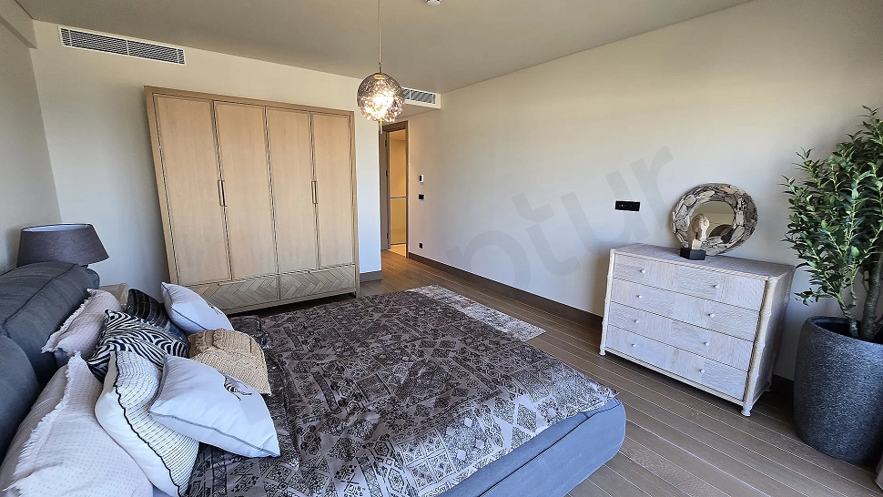Bodrum'da lüks bir villanın gün ışığı alan modern ve geniş yatak odası tasarımı.