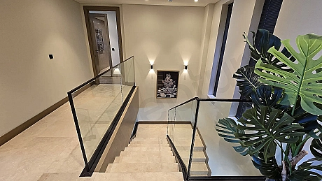 Modern bir villanın iç mekanında yer alan şık ve estetik tasarımlı daire içi merdiven.