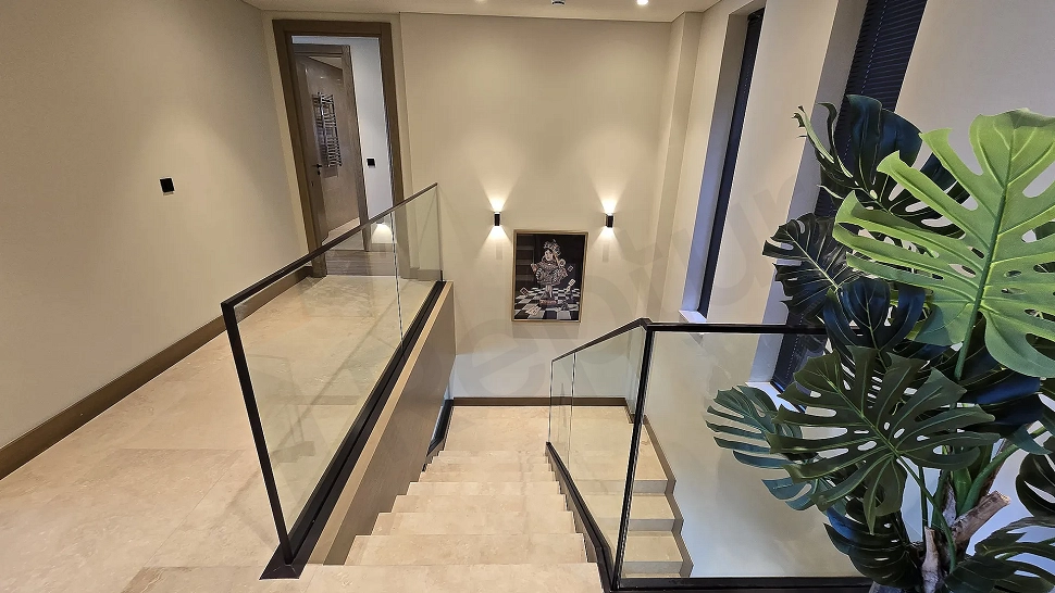 Modern bir villanın iç mekanında yer alan şık ve estetik tasarımlı daire içi merdiven.