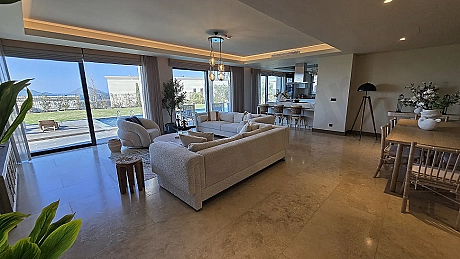 Modern mimariye sahip, geniş ve aydınlık bir villa oturma odası alanı.