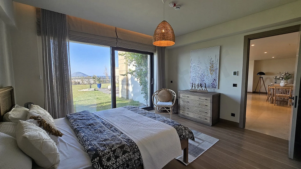 Bodrum'da satılık lüks villanın modern ve geniş tasarımlı aydınlık yatak odası görseli.