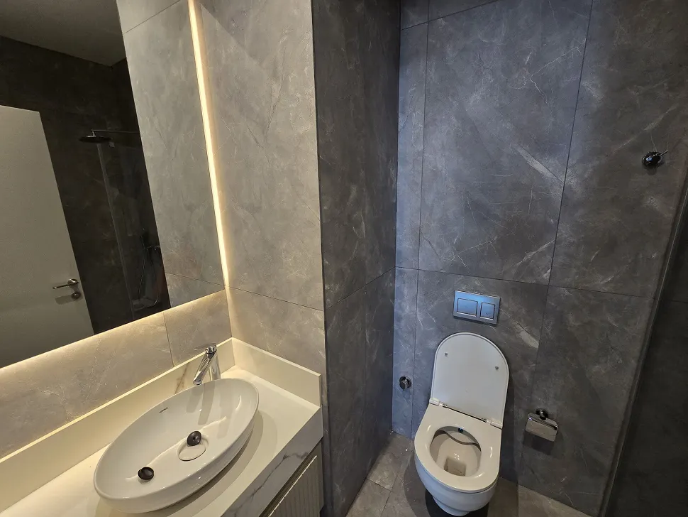 Modern ve şık tasarıma sahip, kaliteli armatür ve seramiklerin kullanıldığı banyo içi görünümü.