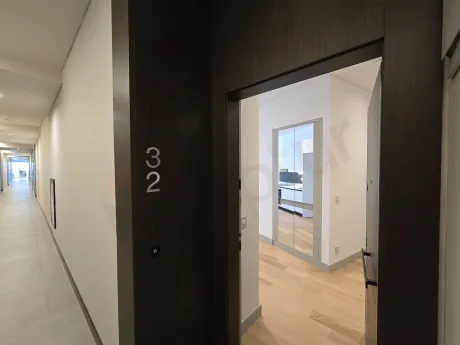 Modern bir dairenin giriş holü ve giriş kapısı görünümü.