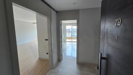 Modern bir dairenin giriş kapısı ve geniş antre görünümü.