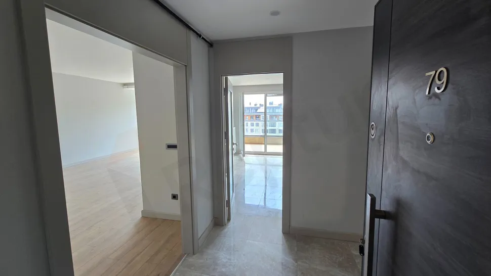 Modern bir dairenin giriş kapısı ve geniş antre görünümü.