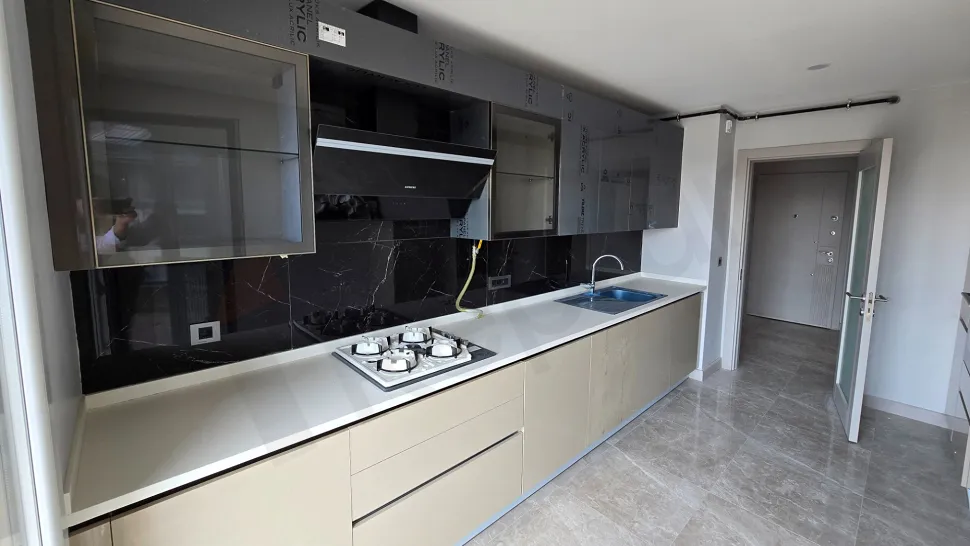 Modern tasarımlı, geniş tezgahlı ve dolaplı mutfak alanı.