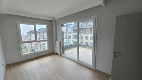 Modern bir yeni binada yer alan, geniş pencereli ve aydınlık yatak odası iç mekanı.