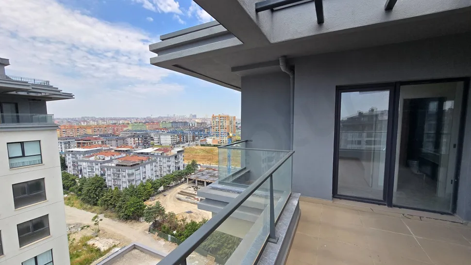 Şehir manzarasına açılan modern ve geniş bir dubleks daire balkonu.