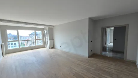 Geniş pencereli, ferah ve modern tasarıma sahip boş bir oturma odası alanı.