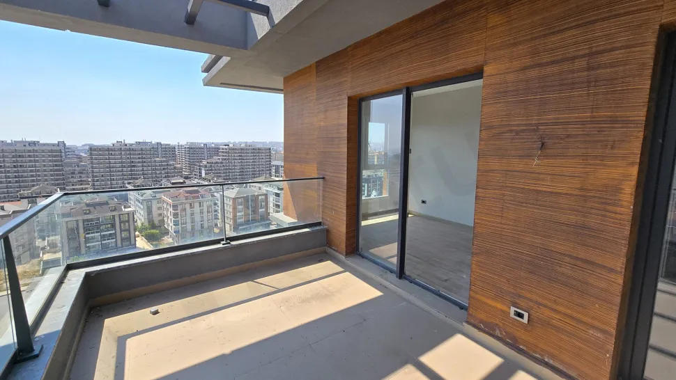 Şehir manzarasına sahip, geniş ve modern bir dubleks daire balkonu.