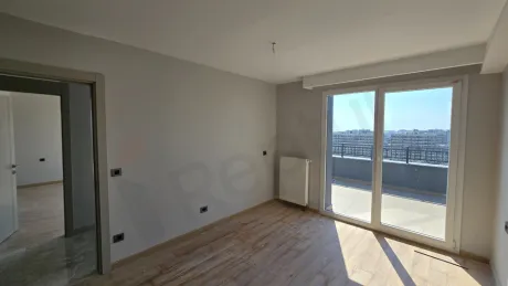 Geniş pencereli, modern tavan aydınlatmalı ve kaliteli zemin döşemesine sahip ferah bir yatak odası görseli.