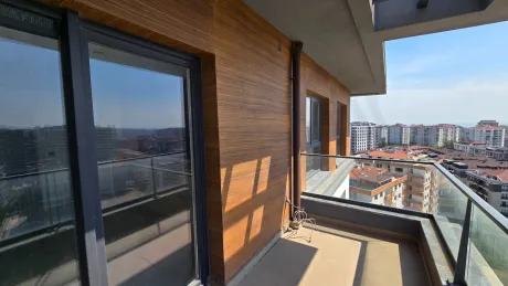 Şehir manzarasına sahip modern ve geniş bir dubleks daire balkonu.
