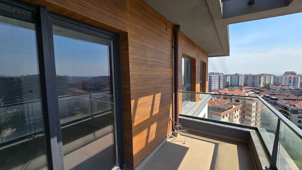 Şehir manzarasına sahip modern ve geniş bir dubleks daire balkonu.