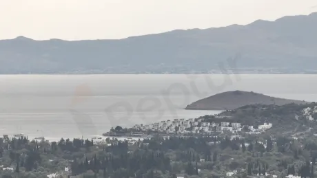 Bodrum sahilinde masmavi deniz ve kıyı şeridini gösteren panoramik manzara.
