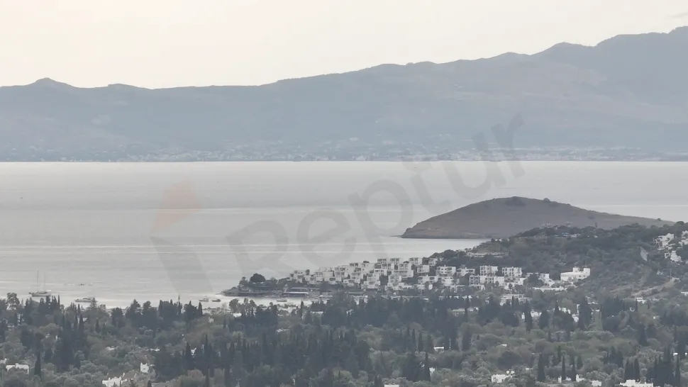Bodrum sahilinde masmavi deniz ve kıyı şeridini gösteren panoramik manzara.