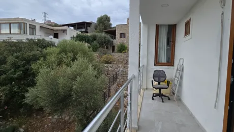 Deniz manzaralı geniş ve modern bir balkonun dış mekan görünümü.