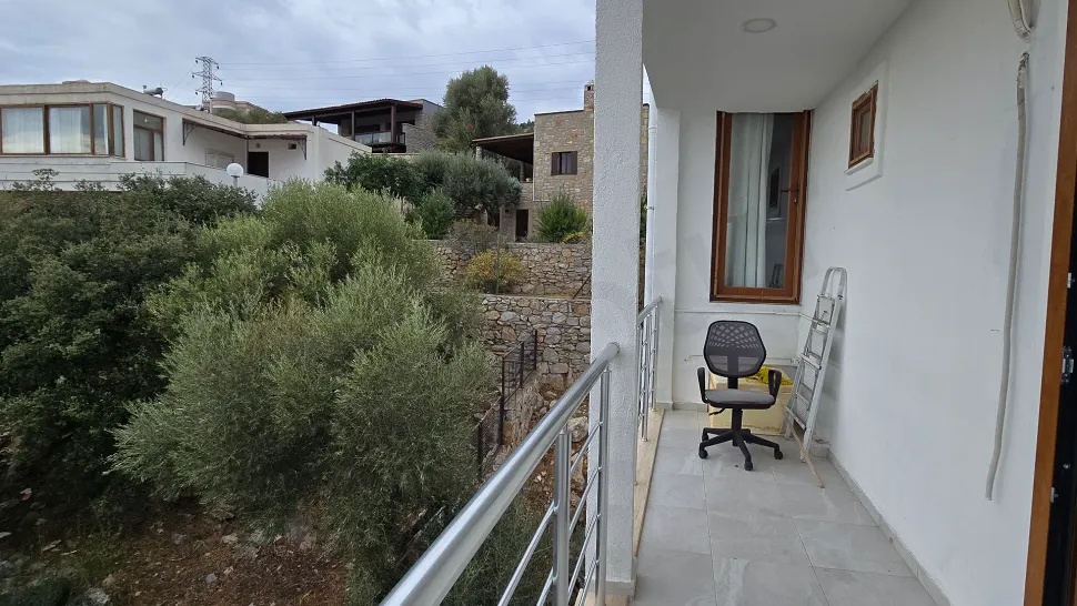 Deniz manzaralı geniş ve modern bir balkonun dış mekan görünümü.