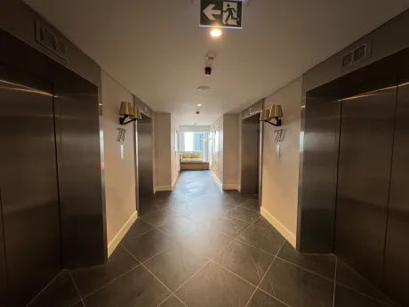 Modern mobilyalı, geniş ve aydınlık bir daire koridoru.