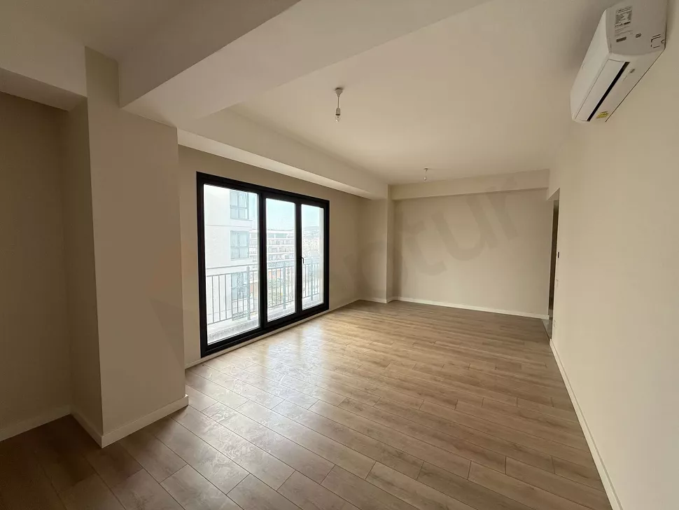 Geniş pencereli, gün ışığı alan modern ve ferah bir oturma odası görünümü.