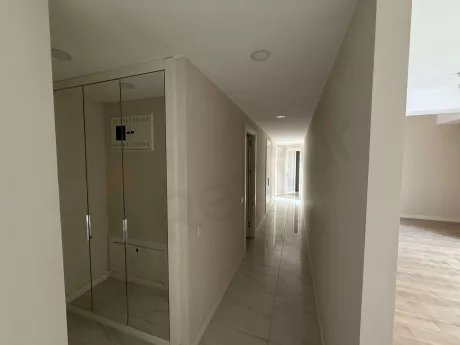 Modern tasarımlı, geniş ve aydınlık bir binanın iç mekan koridor görünümü.