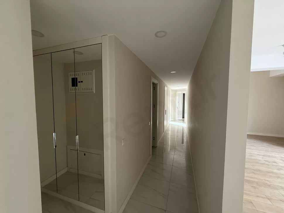 Modern tasarımlı, geniş ve aydınlık bir binanın iç mekan koridor görünümü.