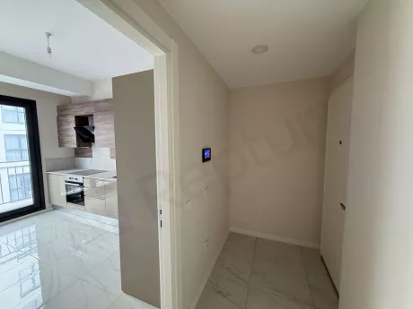 Modern bir apartman dairesinin giriş kapısı ve antre bölümünün görünümü.