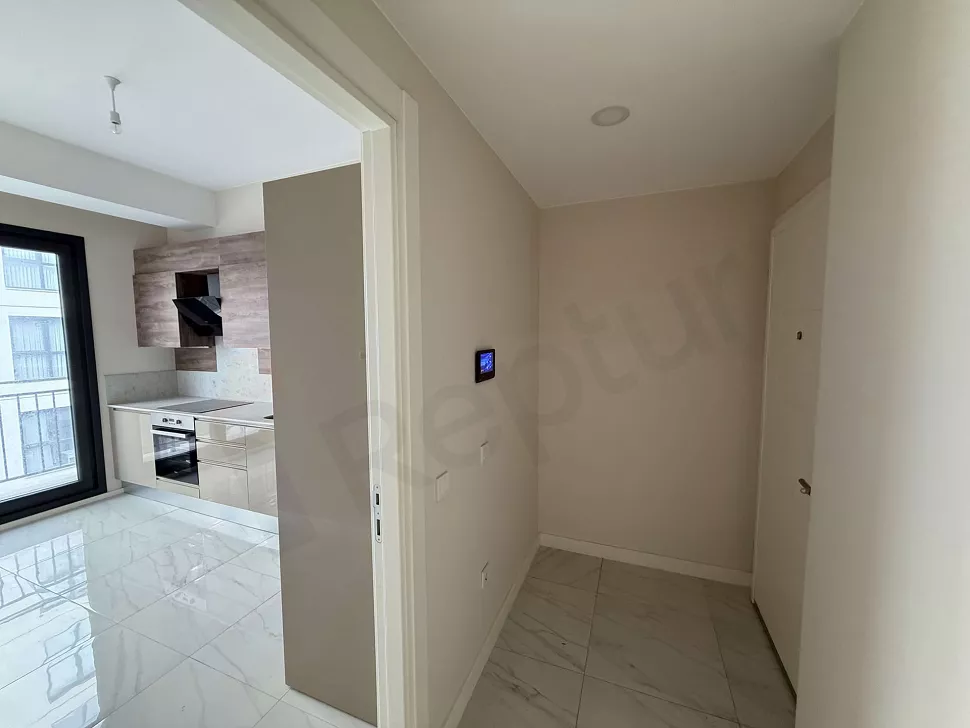 Modern bir apartman dairesinin giriş kapısı ve antre bölümünün görünümü.