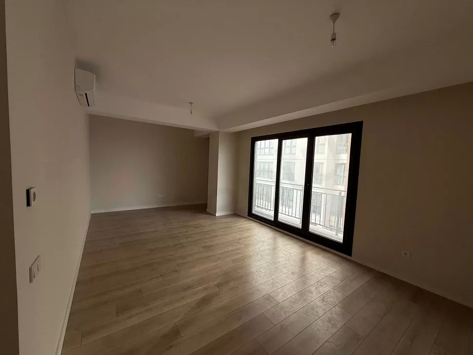 Geniş pencereli, aydınlık ve modern bir oturma odası iç mekanı.